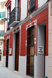 a red and white building with a sign on it at La Casa del Médico in Pego