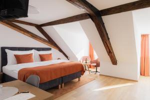 a bedroom with a bed with an orange blanket at Maison Kounic Palace Suites in Slavkov u Brna