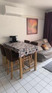 a dining room table with chairs and a couch at Le Thalassa I appartement T2 en bord de plage et du Port in Gruissan