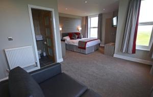 a hotel room with a bed and a couch at Leasowe Castle Hotel in Moreton