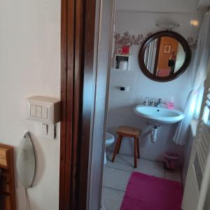 a small bathroom with a sink and a mirror at Casa Noemi Imer in Imer +40 photos