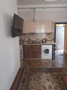 a kitchen with a washing machine and a tv at Guest house in Jermuk