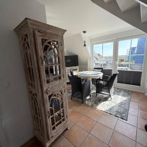 a large wooden cabinet in a living room with a table at Kastanienhüs Apartment in Westerland