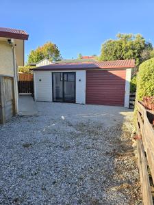 a garage with a red and white garage door at The Old Tin Shed in Wanaka