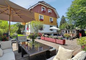 a patio with a table and chairs and a building at Gästehaus Sandvoss in Titisee-Neustadt