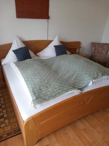 a bed with a green comforter on top of it at Pension Ochsen, Gästezimmer in Unadingen in Löffingen
