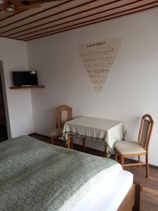 a bedroom with a bed and a table and chairs at Pension Ochsen, Gästezimmer in Unadingen in Löffingen