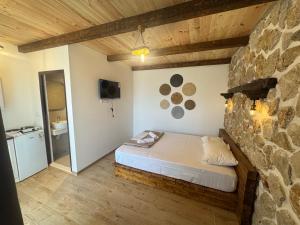 a bedroom with a bed and a stone wall at Medo in Ulcinj