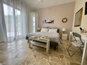 a bedroom with a bed and a table and a chair at Sotto i Monti House in Nicolosi
