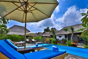 un complexe avec une piscine et un parasol dans l'établissement Sunset Coin Lembongan, à Nusa Lembongan