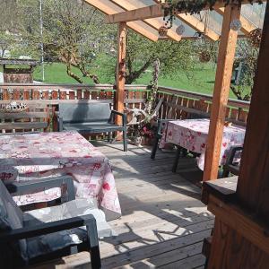 a patio with tables and benches on a wooden deck at Casa Noemi Imer in Imer