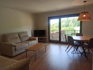 a living room with a couch and a table at Apartamentos Cal Itxió de Molló Parc in Molló