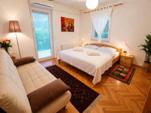 a bedroom with a white bed and a couch at Apartments Poldi in Bled +65 photos