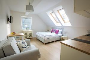 a living room with a bed and a couch at Ava Apartamenty in Niechorze