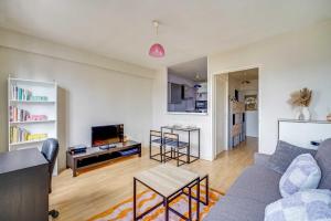 a living room with a couch and a tv at Spacious Studio 2P - Near La Défense in Courbevoie +4 photos