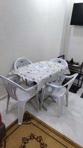 a white table and chairs with a table cloth on it at Duplex al menzah in Tamaris