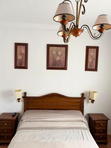 a bedroom with a bed and three pictures on the wall at Hidalgo in Alcaudete