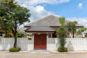 a house with a white fence and a wooden door at Southern Lanta C9 in Ko Lanta