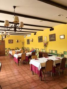 a dining room with tables and chairs and yellow walls at Hidalgo in Alcaudete