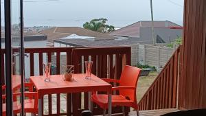 a red table and chairs sitting on a balcony at 27 on Brunswick in Gqeberha +112 photos