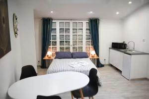 a bedroom with a bed and a table with chairs at Logement Poséidon in Boulogne-sur-Mer