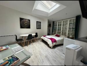 a bedroom with a bed and a desk and a table at Logement Poséidon in Boulogne-sur-Mer