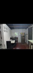a kitchen with a table and chairs and a refrigerator at Casa,del vozque in Manzanillo