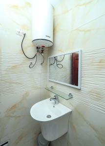 a bathroom with a white sink and a mirror at Villa les 3 oisillons in Kribi +25 photos