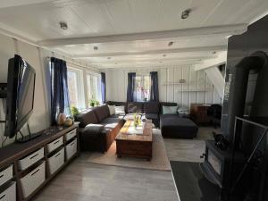 a living room with a couch and a table at Snemyr i Høvåg in Høvåg