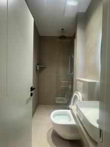 a bathroom with a white toilet and a sink at Elios Near Centre Apartment in Tirana +36 photos