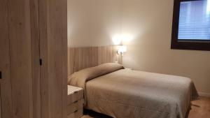 a small bedroom with a bed and a window at Apartamentos Cal Itxió de Molló Parc in Molló