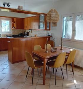a kitchen with a wooden dining room table and chairs at Aethalios katoikia in Korissia