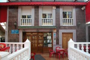 a building with red chairs and tables in front of it at Hidalgo in Alcaudete