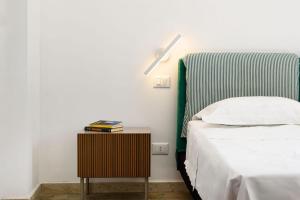 a bedroom with a bed and a side table with a lamp at Sinedda Sole in San Vito lo Capo
