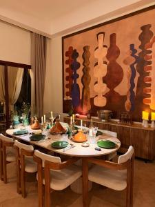 a dining room with a table with chairs and a painting at Villa Dar Al Hayat in Marrakesh