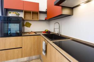 a kitchen with wooden cabinets and a sink at Sinedda Sole in San Vito lo Capo +11 photos