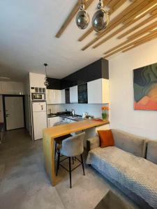 a kitchen and living room with a table and a couch at Pool View Studio Apartment Caesar Resort & Spa in Dherinia