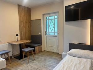 a bedroom with a bed and a desk and a window at Gasthof Paradiesgartl in Kleinpöchlarn