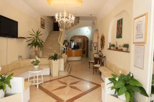 a living room with a staircase and a chandelier at Hotel Adriatica sul Mare in Rimini