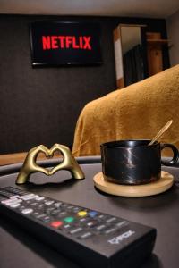 a remote control and a cup on a table at Zen Lux in Zaječar