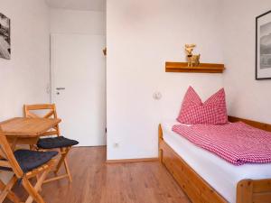 a bedroom with a bed and a chair and a table at SONNENSEITE Schonach - Private Infrarot-Sauna - Schwarzwald-Panoramablick - 2 separate Schlafzimmer - Ruhige Lage am Waldrand in Schonach