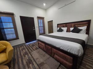 a bedroom with a large bed and a yellow chair at Samlaun in Pauri