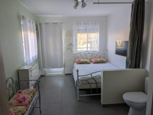 a small bedroom with two beds and a chair at Chambre avec petit déjeuner in Condom