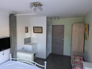 a bedroom with a bed and a sink and a bathroom at Chambre avec petit déjeuner in Condom
