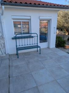 a bench sitting on a patio in front of a house at Chambre avec petit déjeuner in Condom