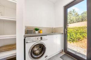a laundry room with a washing machine and a window at Bright Vista with Studio in Bright