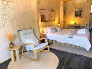 a bedroom with two beds and a chair and a table at Bright Vista with Studio in Bright