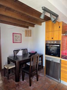 a kitchen with a table and chairs and a stove at Casa Pedra da Foz in Odeceixe