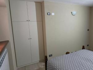 a bedroom with a bed and a large white cabinet at Alloggio valle stura in Vinadio
