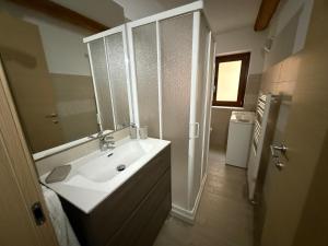 a bathroom with a white sink and a mirror at Alloggio valle stura in Vinadio